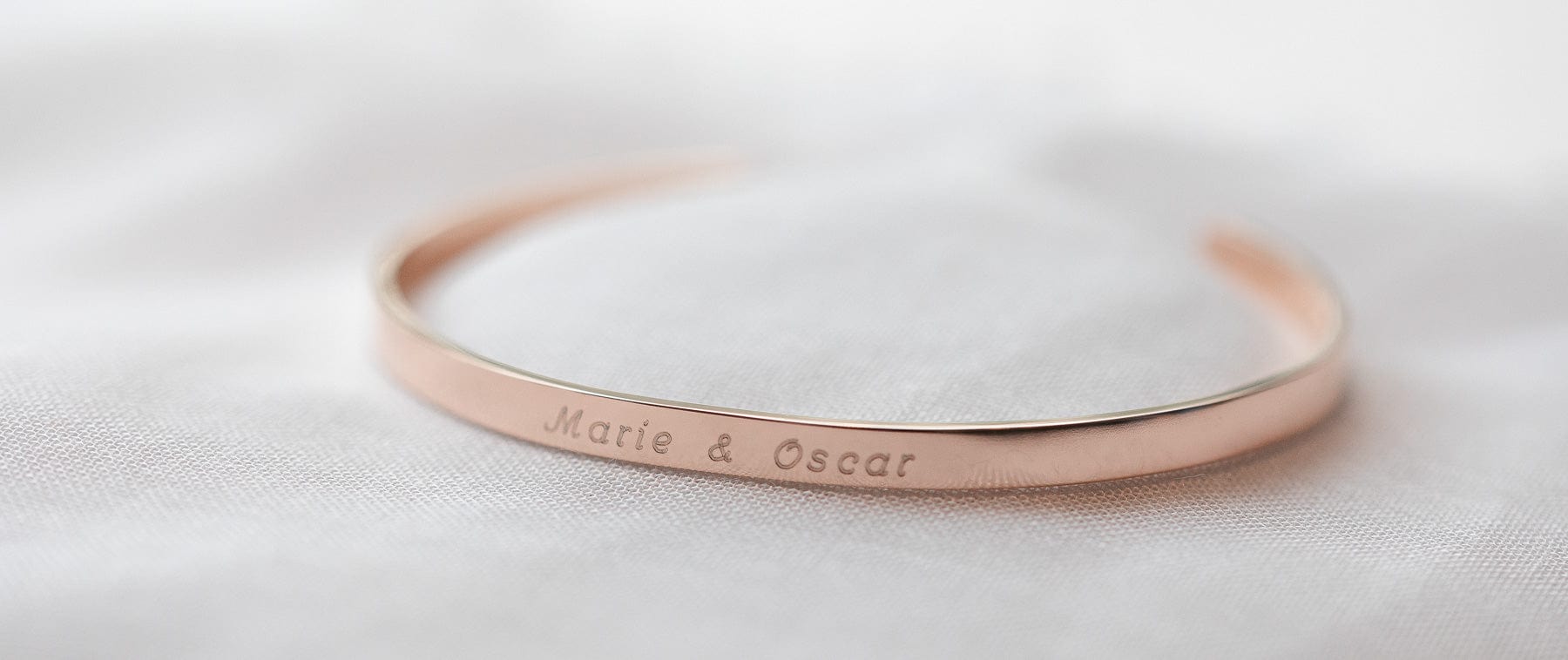 Personalisierter schmaler Armreif mit Koordinaten Gravur auf der Innenseite in rosegold matt für Damen als geschenk für die beste Freundin oder als Abschiedsgeschenk fuer die Kollegin steht auf einem weißen Sfoffuntergrund