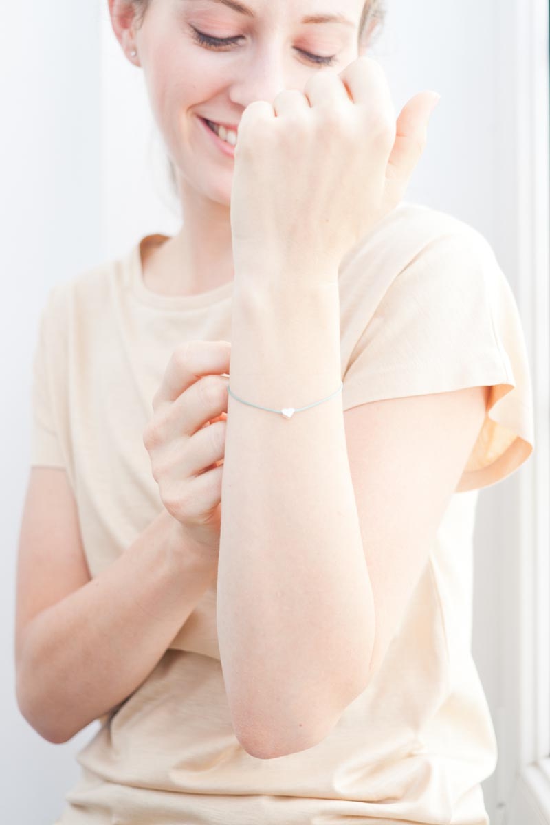 Weibliches Model traegt nachhaltiges und Armband mit Herz aus fairer Produktion von Oh Bracelet Berlin