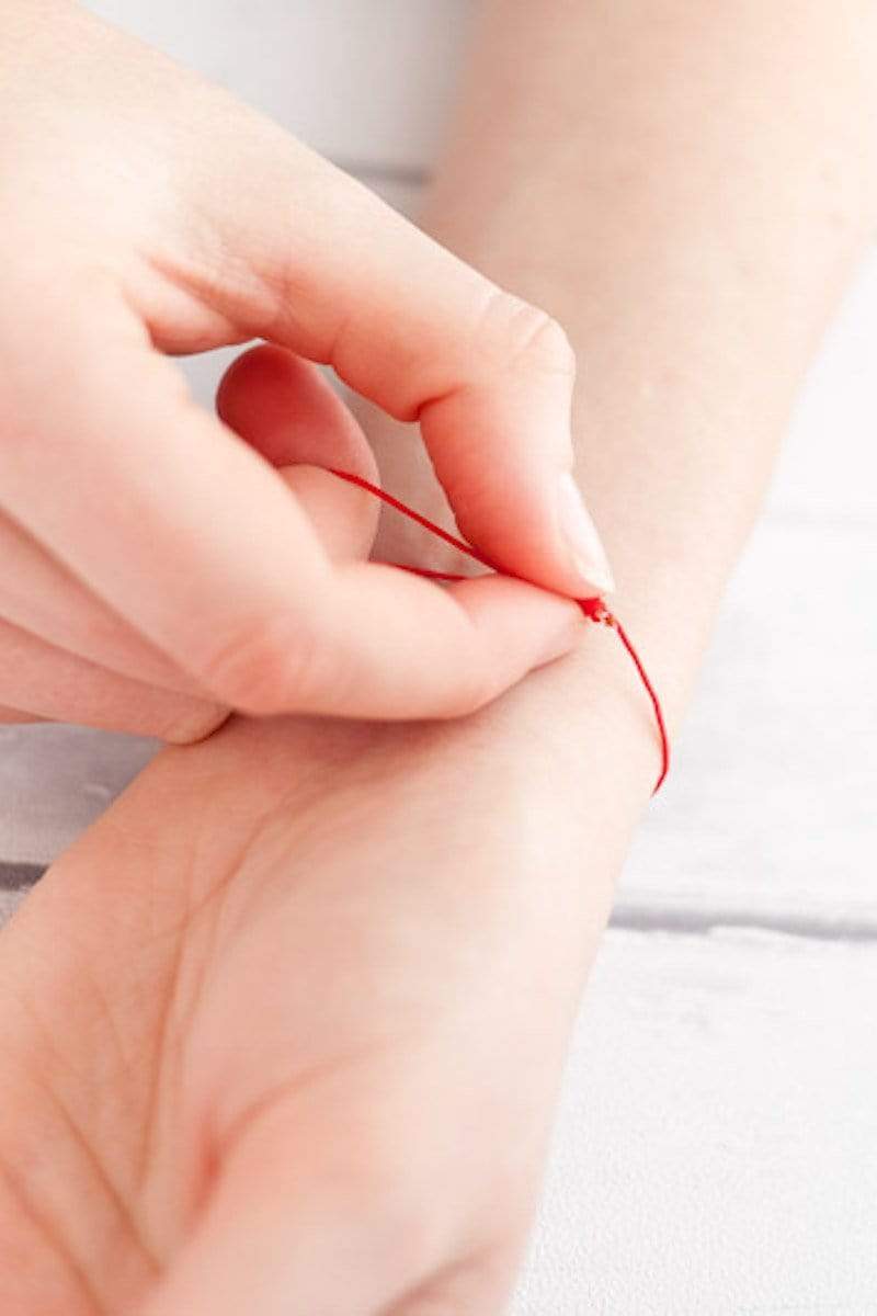 Handmodel zeigt Schiebeknotenverschluss von einem Armband aus Nylon
