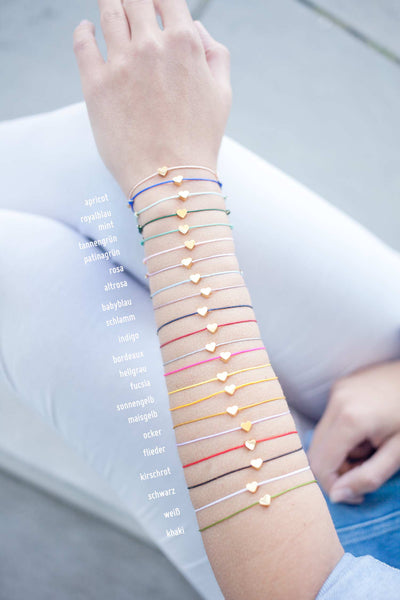 Armbänder mit Herz werden am Arm präsentiert in unterschiedlichen farbenfrohen Farben